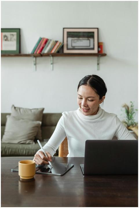 Confident woman freelancing on a laptop and tablet