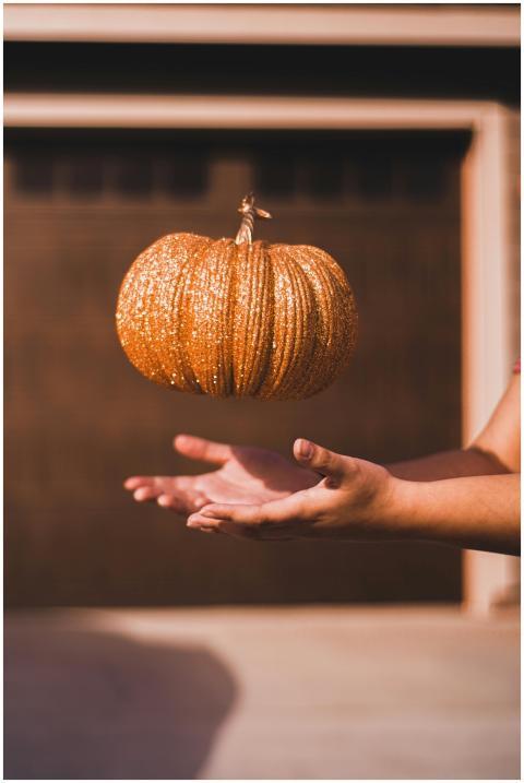 A glittering pumpkin floats above hands during fal