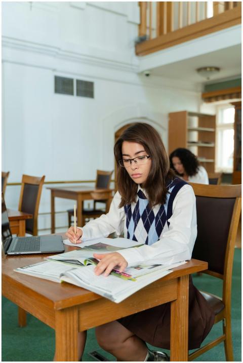 Young woman in a library, focused on studying with