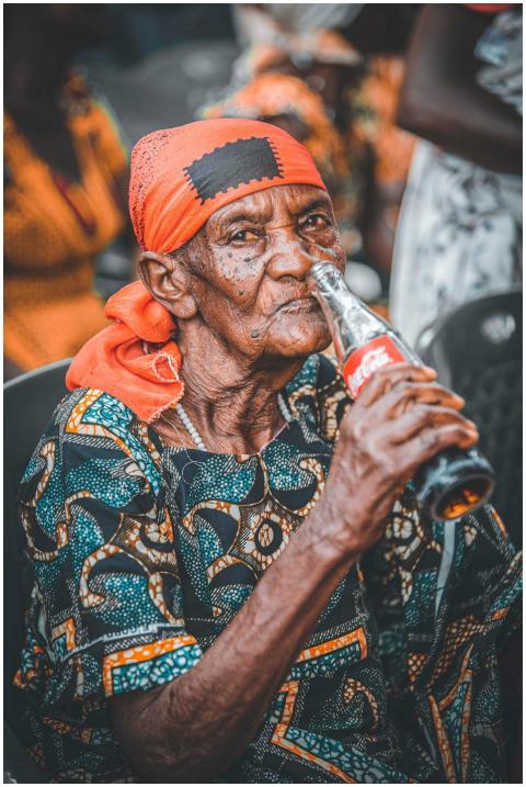 Elderly woman in traditional clothing enjoying a C