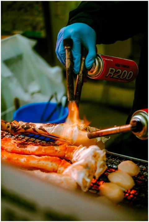 A street vendor grills fresh crab legs with blowto