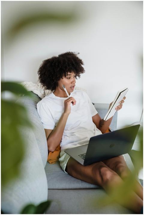 Focused young woman studying at home with a laptop