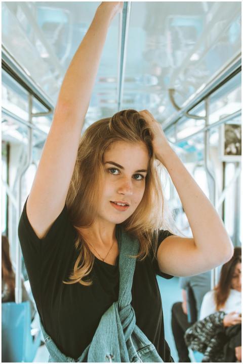 Woman posing inside a modern train, showcasing urb
