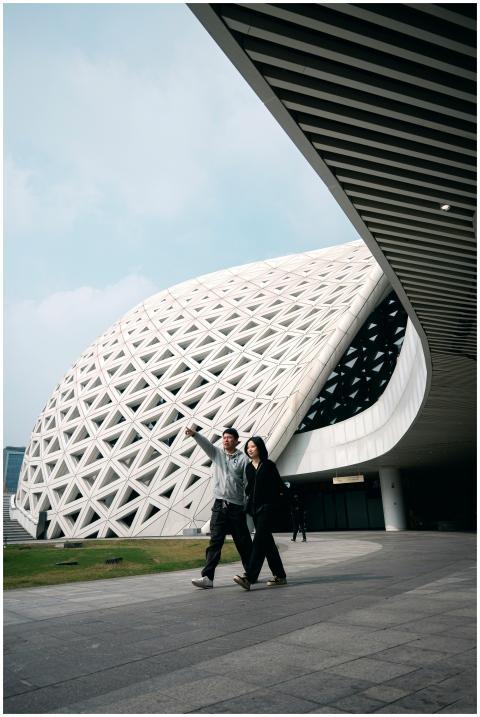 Couple walking near futuristic architectural struc