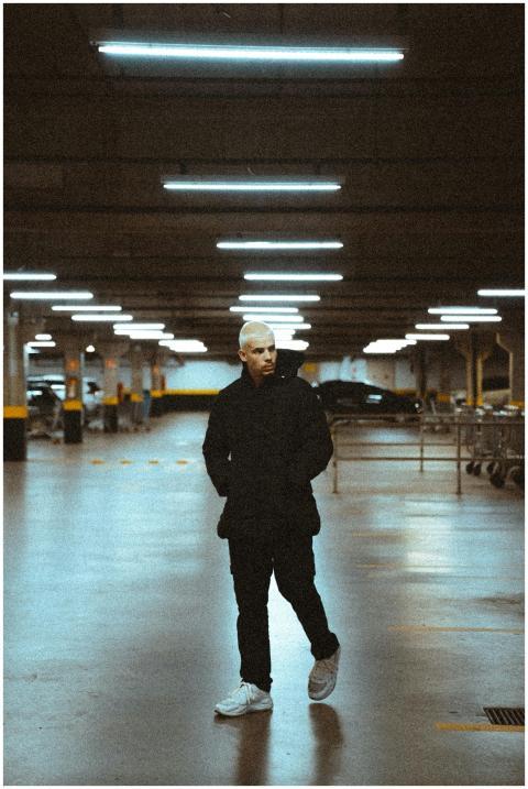 Stylish man in black clothing walking in dimly lit