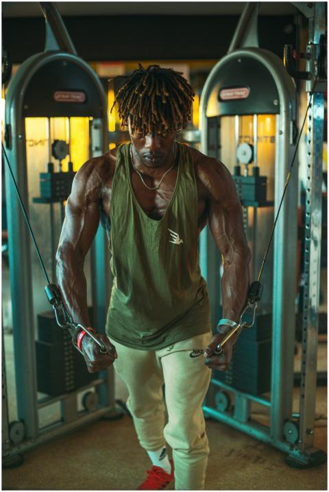 Muscular man performing cable exercises in a moder