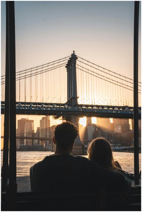 A romantic couple watches the sunset behind the ic