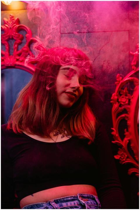 Stylish woman enjoying nightlife with colorful lig