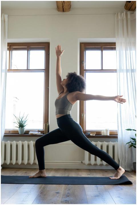 Woman practicing yoga in a well-lit modern home se