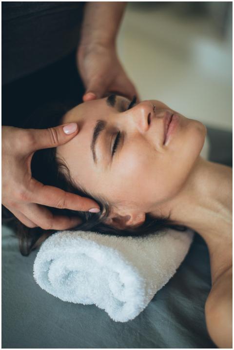 Woman enjoying a soothing facial massage at a spa,