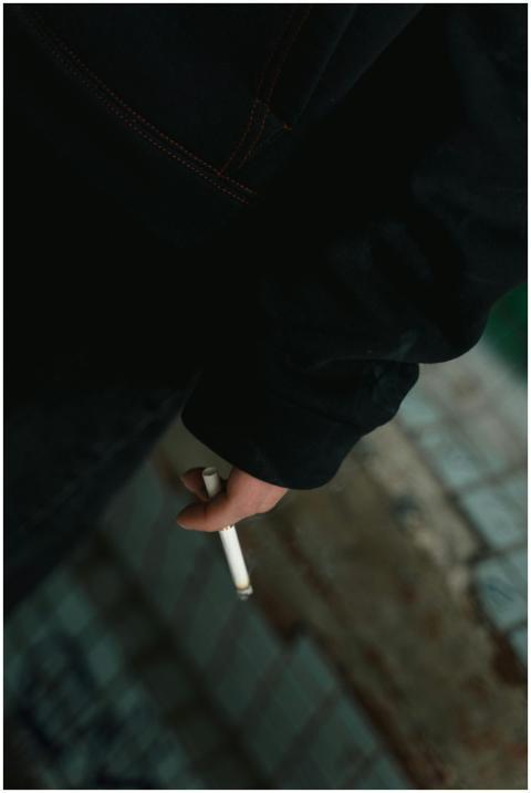 Moody photo of a person's hand holding a cigarette