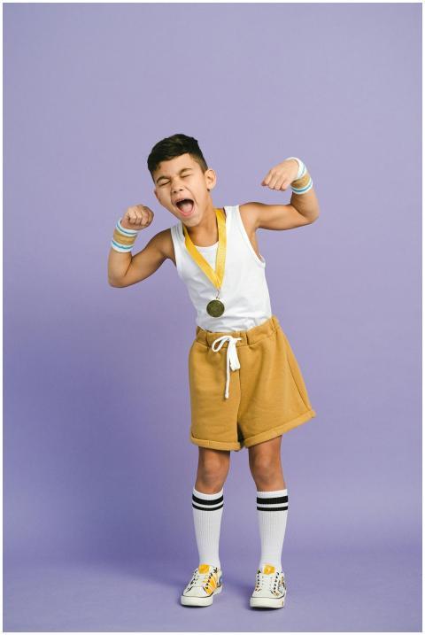 Young boy in sporty attire celebrating a victory w