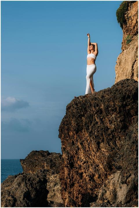 A woman in white clothing stands elegantly on a sc
