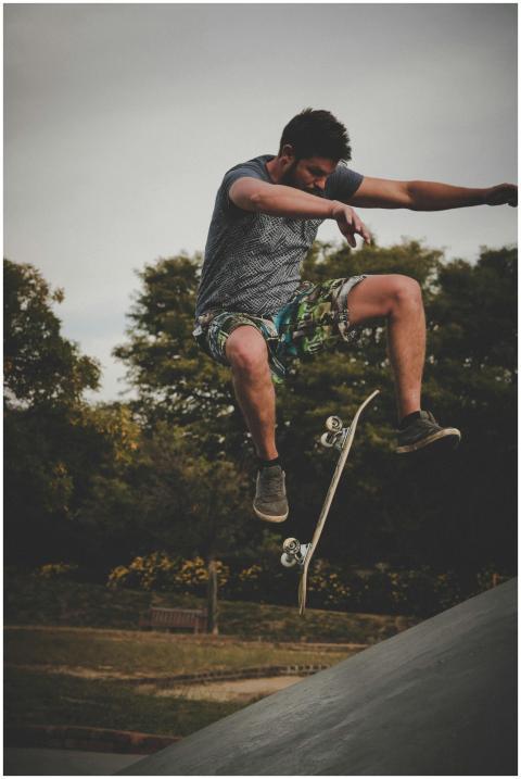 Young man executing an aerial skateboard trick in