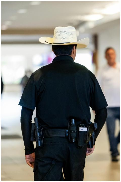 Security guard with cowboy hat patrolling inside a