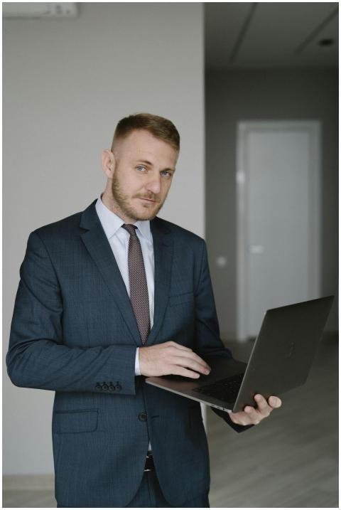 Young businessman in a suit using a laptop indoors