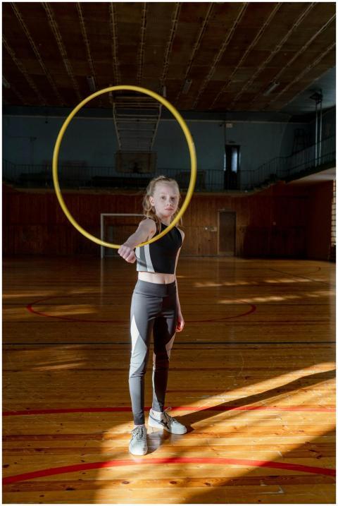 A child in sportswear practicing hula hooping indo