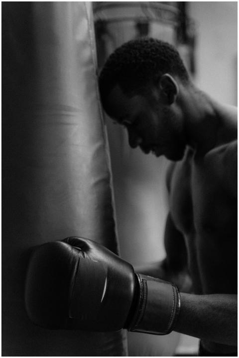 A focused boxer in the gym preparing for an intens