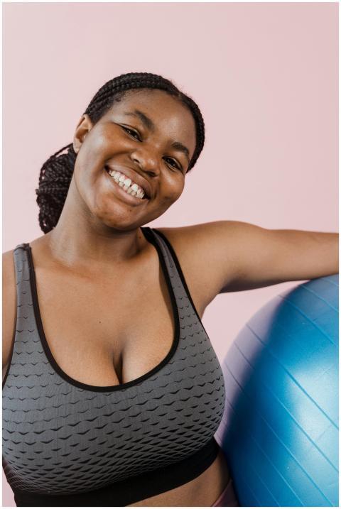 Happy woman with afro braids in a sports bra posin