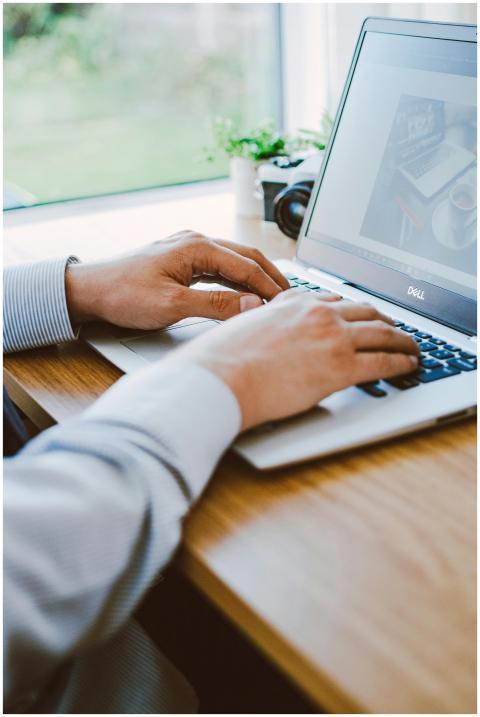 A man working on a laptop in a modern office setti