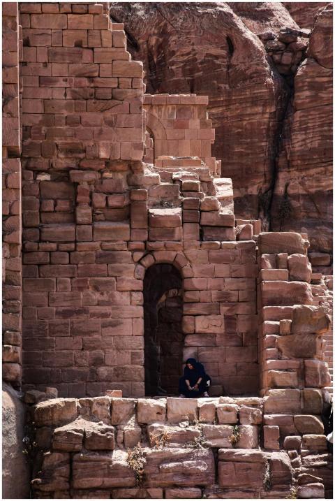 Ancient stone ruin with a person sitting, located