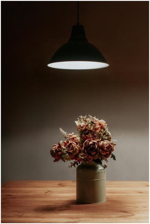 A warm, minimalist floral arrangement under soft l