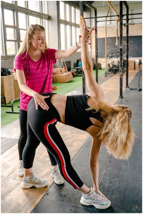 Female personal trainer assisting woman during a s