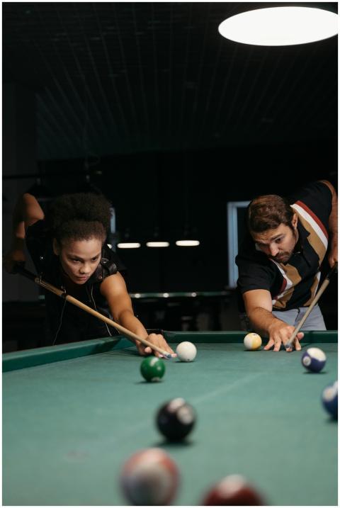 A focused match between two adults playing billiar