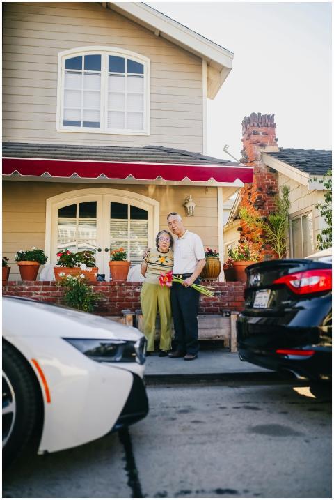 Elderly couple hugging on patio with flowers, depi