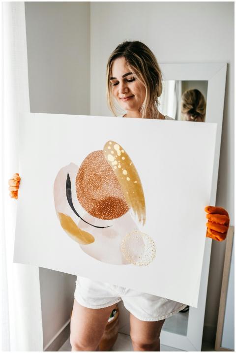 A woman with closed eyes holding a colorful abstra