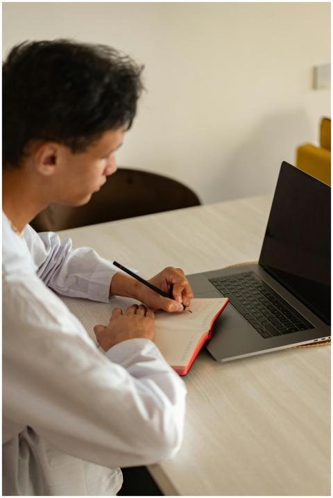 A young man focusing on his studies at home, using