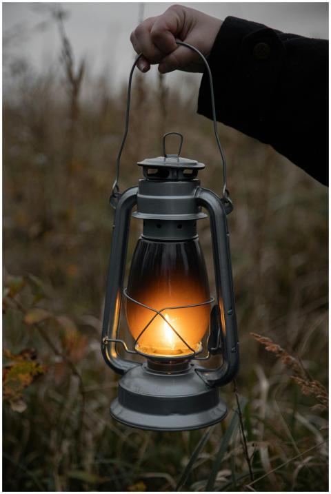 A vintage lantern glowing with warm light, held in