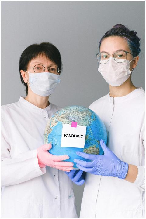 Two healthcare workers holding a globe labeled 'Pa