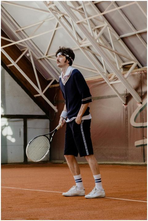 Young man holding a tennis racket on an indoor cla