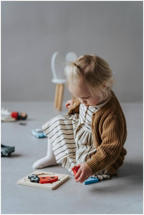 Young child in cozy outfit playing with a puzzle i