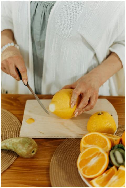 A woman cutting lemons in the kitchen, preparing f