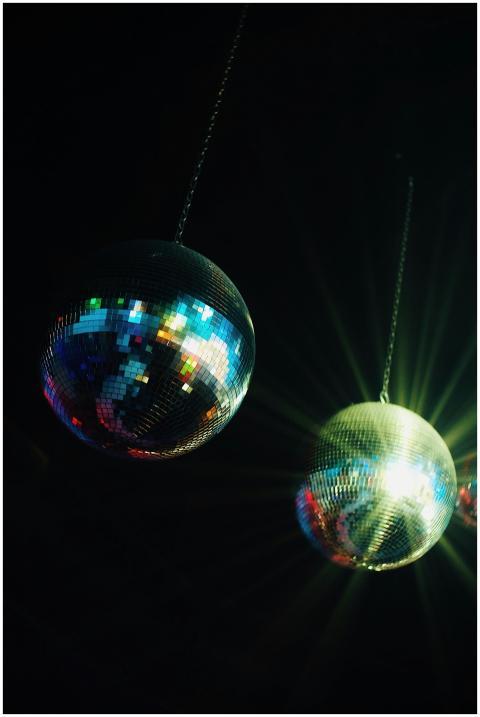 Two shining disco balls with colorful light reflec