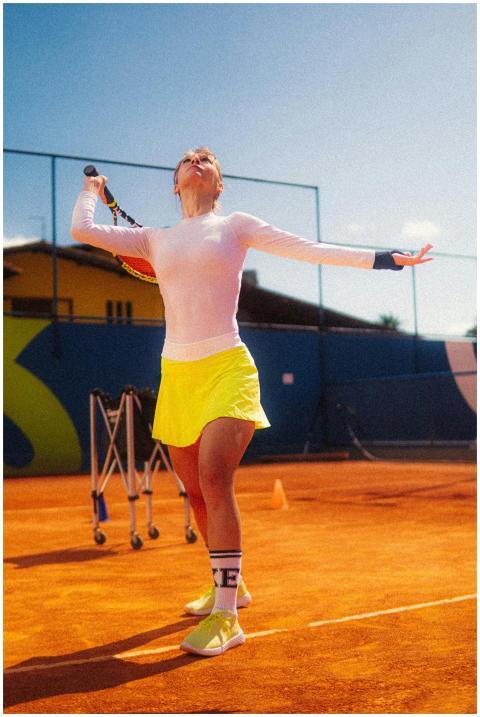Dynamic shot of a young female tennis player servi