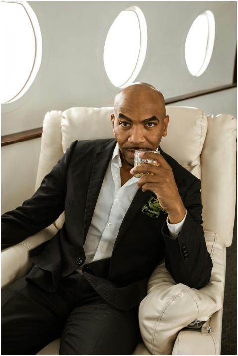Businessman in black suit enjoying a drink while f