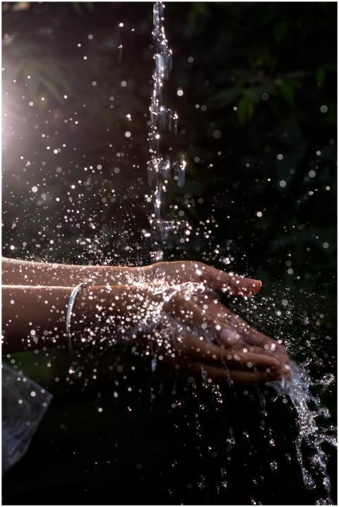 A vivid close-up of water splashing over cupped ha
