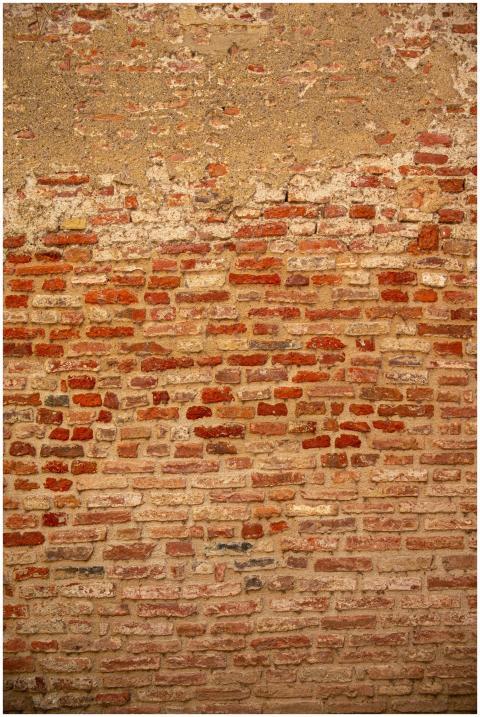 Close-up of a weathered brick wall showcasing text