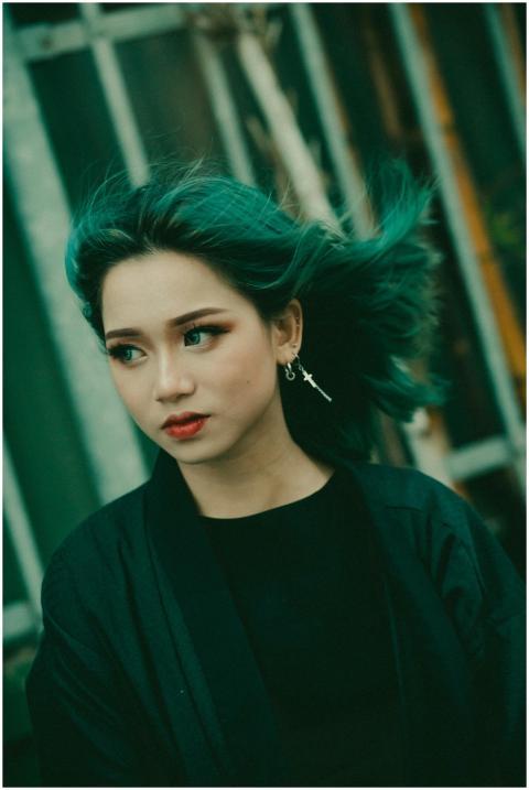 Young woman with vibrant green hair posing outdoor