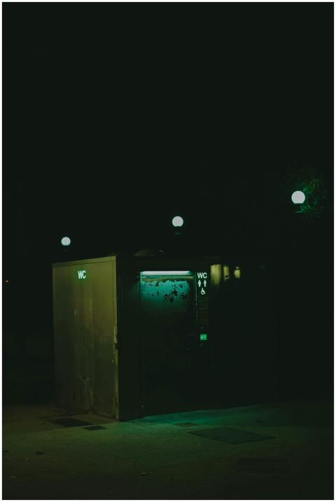 Dark nighttime scene of a public toilet illuminate