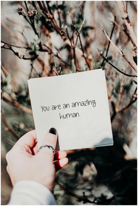Hand holding an inspirational quote card against a