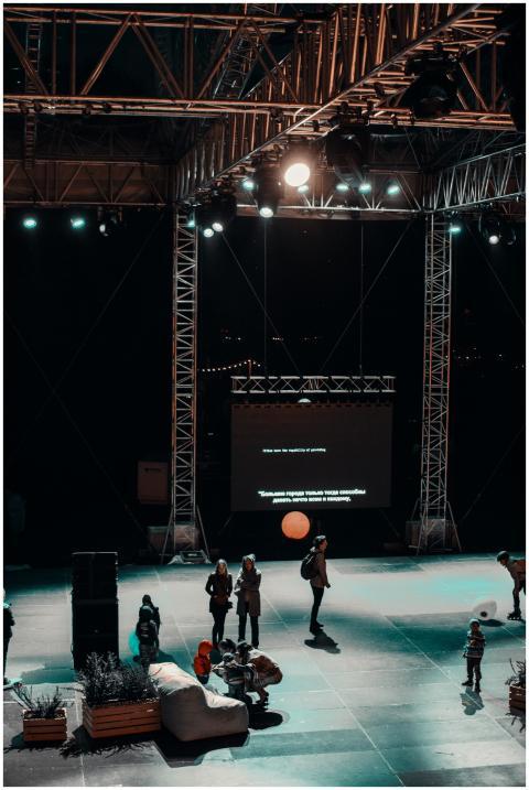 A vibrant nighttime stage setup with a crowd, ligh