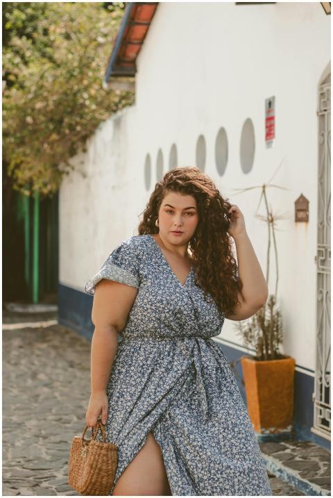 Stylish woman in a blue floral dress standing conf