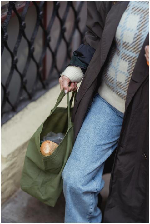 A woman walks outdoors carrying an eco-friendly ba