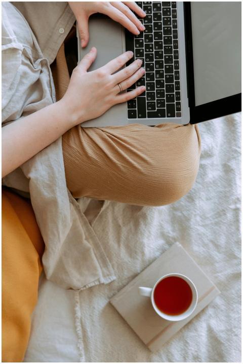 Anonymous woman in casual clothes sitting on sofa
