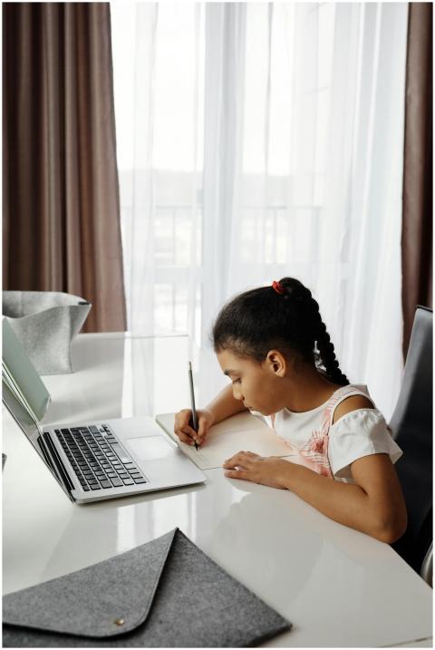 A young girl focuses on her studies at home using