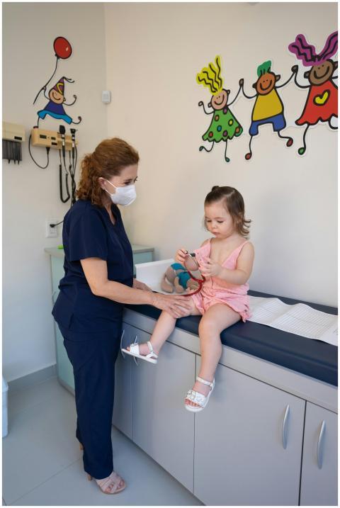 A child is examined by a nurse in a pediatrician's
